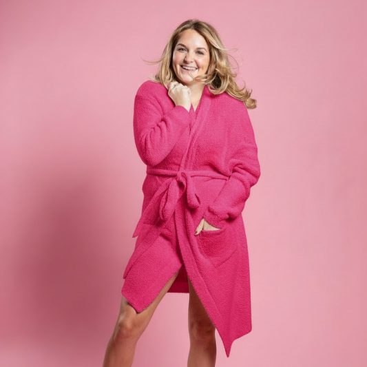Woman wearing a bright pink robe against a pink background