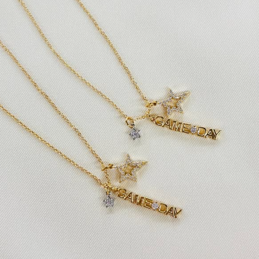 Two gold necklaces with star and 'GAME DAY' pendants on a light background